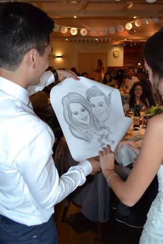 Invitados recibiendo su caricatura durante el banquete de una boda