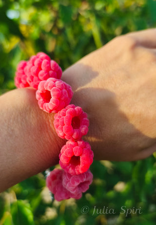 Velvety polymer clay raspberry bracelet worn on a wrist outdoors in natural sunlight with green garden background — Julia Spiri